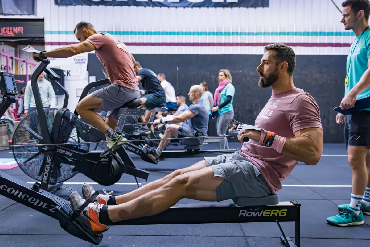 Side-by-side comparison of CrossFit barbell and HYROX sled